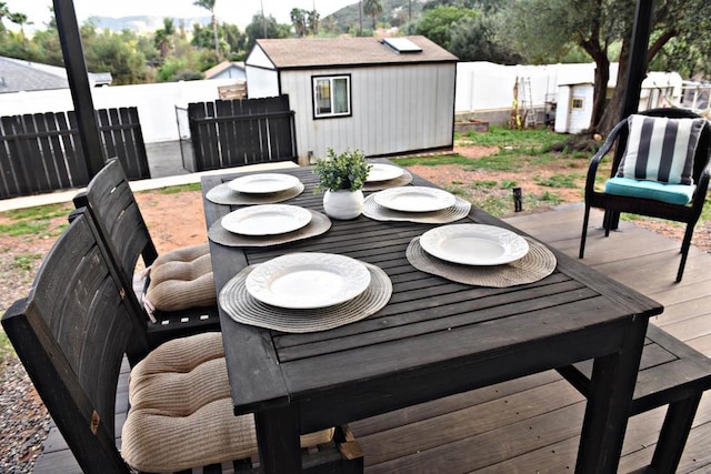 wooden deck with a storage shed, an outbuilding, and a fenced backyard