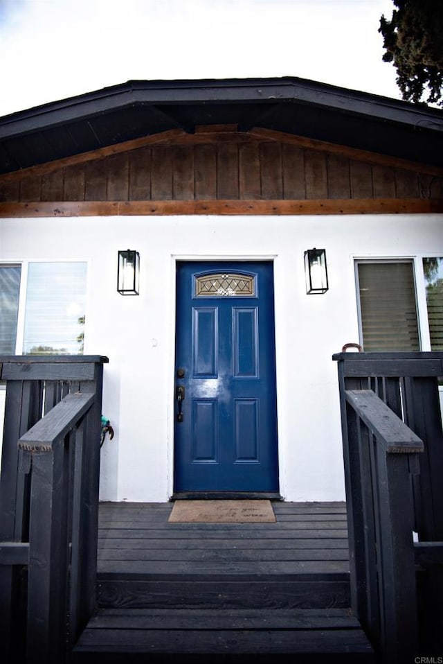 doorway to property featuring stucco siding
