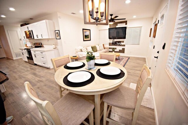 dining room with ceiling fan with notable chandelier, light wood-style flooring, baseboards, visible vents, and recessed lighting