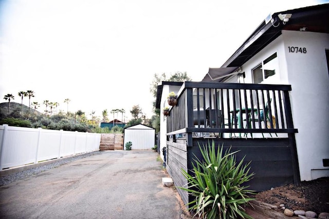 view of home's exterior with fence, a shed, an outdoor structure, and stucco siding