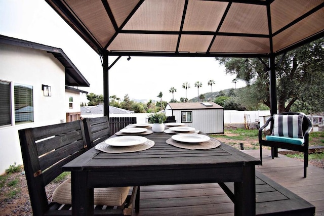 deck featuring an outdoor structure, a gazebo, fence, and a shed