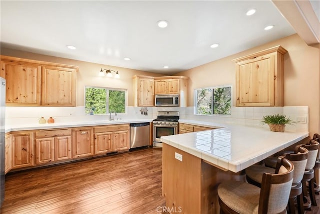 28136 N Bay Rd, Lake Arrowhead, CA 92352 - kitchen featuring stainless steel appliances, light brown cabinets, backsplash, a peninsula, and a sink