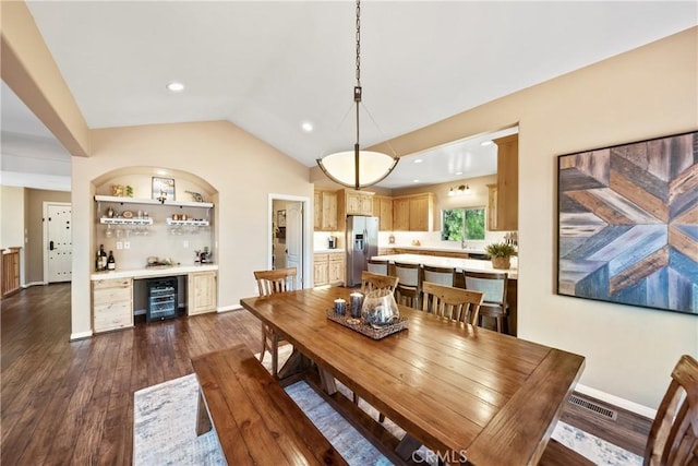 28136 N Bay Rd, Lake Arrowhead, CA 92352 - dining space with wine cooler, a dry bar, vaulted ceiling, dark wood-style flooring, and baseboards