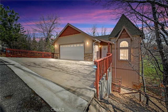 28136 N Bay Rd, Lake Arrowhead, CA 92352 - view of front of house with driveway, stone siding, a garage, and roof with shingles