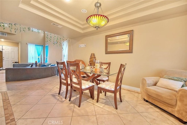 dining room with visible vents, light tile patterned floors, and a tray ceiling