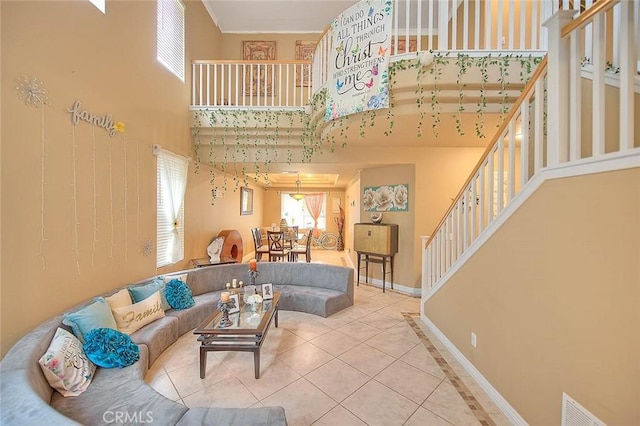 living area with a high ceiling, tile patterned floors, stairs, and a wealth of natural light