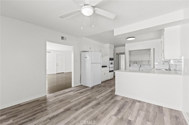 1729 S Alma St, San Pedro, CA 90731 - kitchen with freestanding refrigerator, washer and dryer, light wood finished floors, white cabinets, and light countertops