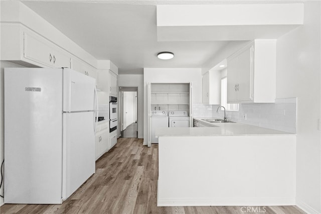 1729 S Alma St, San Pedro, CA 90731 - kitchen with white appliances, independent washer and dryer, a peninsula, a warming drawer, and light wood-style flooring
