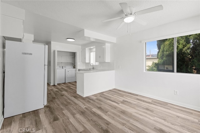 1729 S Alma St, San Pedro, CA 90731 - unfurnished living room with washing machine and clothes dryer, light wood finished floors, ceiling fan, and a textured ceiling