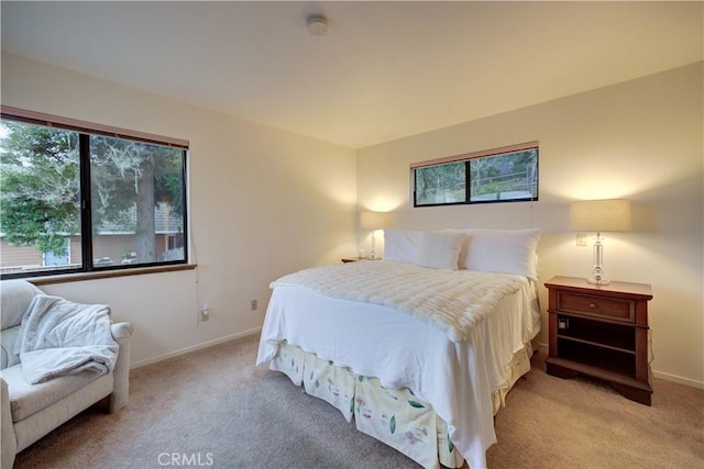 bedroom featuring light carpet and baseboards