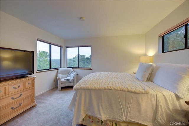 bedroom featuring baseboards, light colored carpet, and multiple windows
