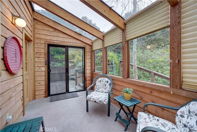 sunroom featuring beamed ceiling and a skylight
