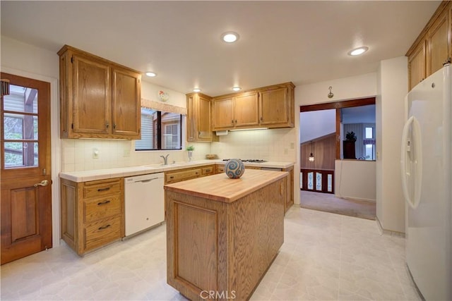 kitchen featuring decorative backsplash, butcher block counters, white appliances, and plenty of natural light