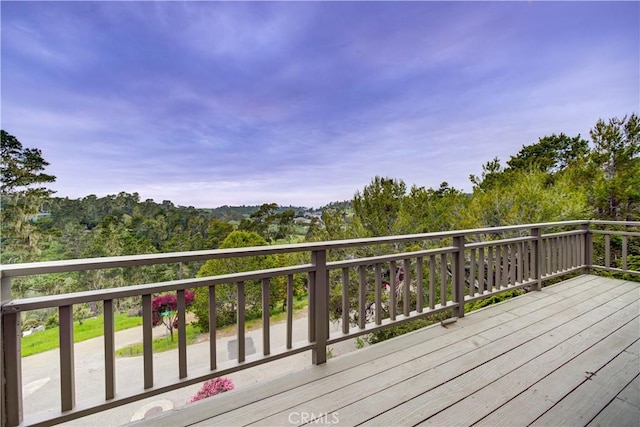 wooden deck featuring a forest view
