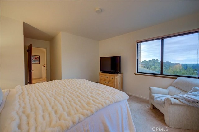 bedroom with light carpet and baseboards