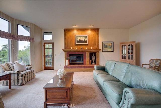 living area with a large fireplace and light colored carpet