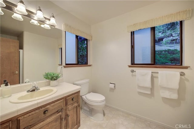 bathroom featuring tile patterned flooring, toilet, vanity, and baseboards