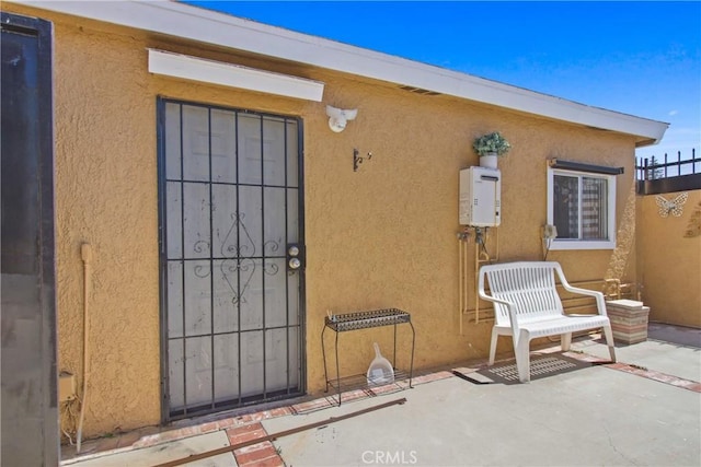 doorway to property with stucco siding and a patio