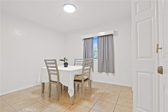 dining space with baseboards and light tile patterned floors