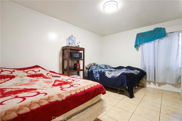 bedroom with light tile patterned flooring and crown molding