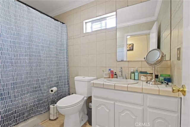 bathroom with curtained shower, toilet, vanity, ornamental molding, and tile walls