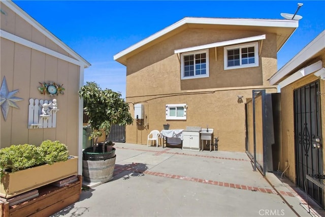 back of house featuring stucco siding, fence, and a patio