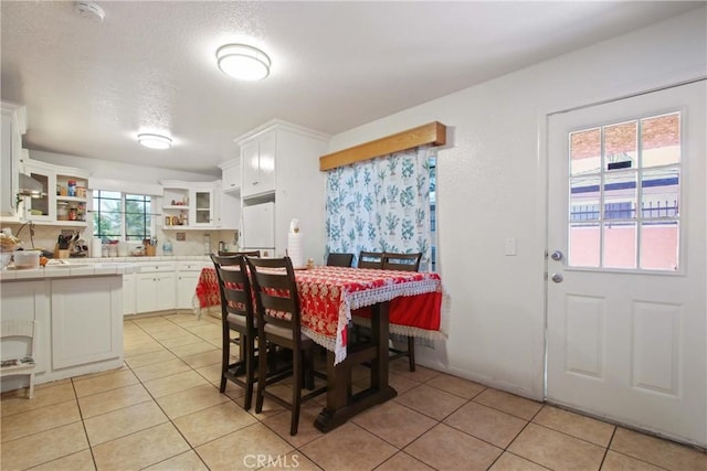 dining space with a textured ceiling and light tile patterned floors
