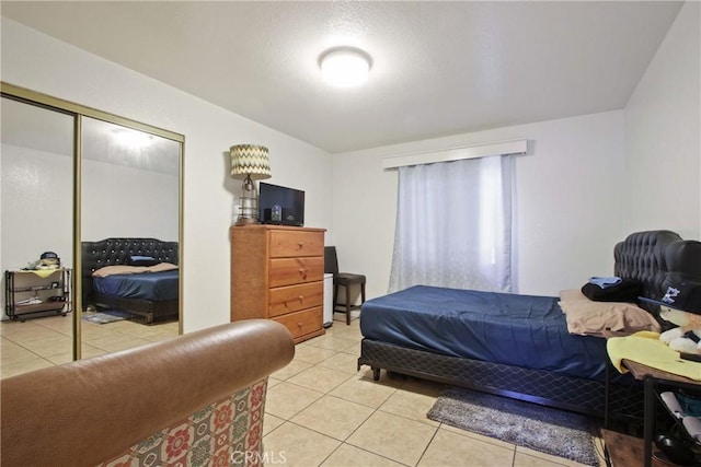 bedroom with light tile patterned flooring and a closet