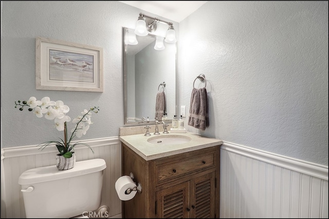 23962 Lanteen Cir, Laguna Niguel, CA 92677 - half bathroom featuring wainscoting, toilet, vanity, and a textured wall