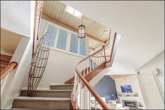 23962 Lanteen Cir, Laguna Niguel, CA 92677 - staircase with beam ceiling, a high end fireplace, wooden ceiling, and baseboards