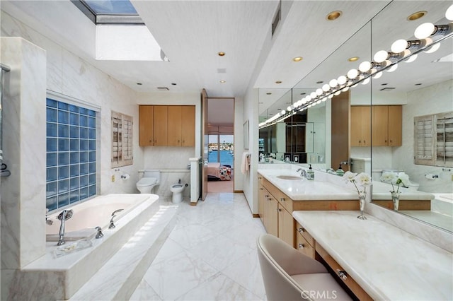 812 W Bay Ave, Newport Beach, CA 92661 - bathroom featuring a bidet, vanity, a bathing tub, and a skylight