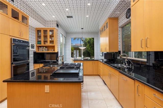 812 W Bay Ave, Newport Beach, CA 92661 - kitchen featuring a kitchen island with sink, dark stone countertops, dobule oven black, and a sink