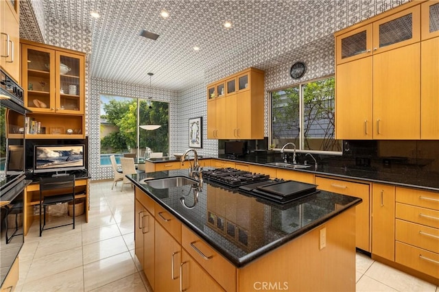 812 W Bay Ave, Newport Beach, CA 92661 - kitchen with dark stone counters, wallpapered walls, an island with sink, and a sink
