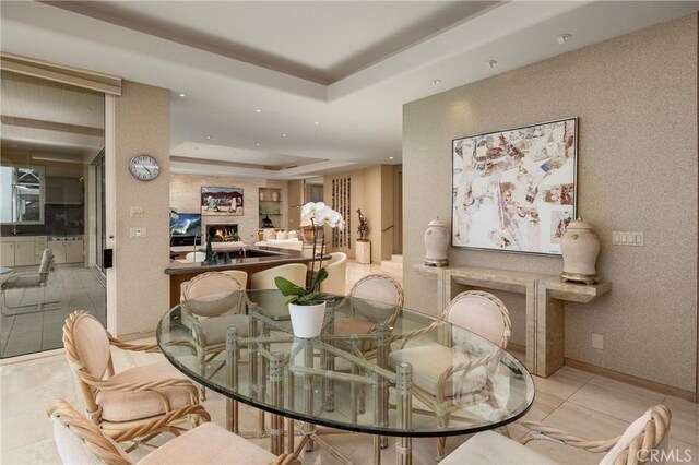812 W Bay Ave, Newport Beach, CA 92661 - tiled dining space featuring a fireplace, a raised ceiling, and recessed lighting
