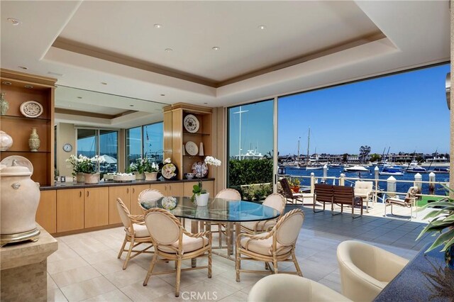 812 W Bay Ave, Newport Beach, CA 92661 - dining room featuring a tray ceiling, expansive windows, a water view, and light tile patterned flooring