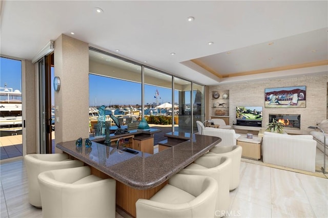 812 W Bay Ave, Newport Beach, CA 92661 - kitchen featuring a sink, expansive windows, dark stone counters, open floor plan, and a glass covered fireplace