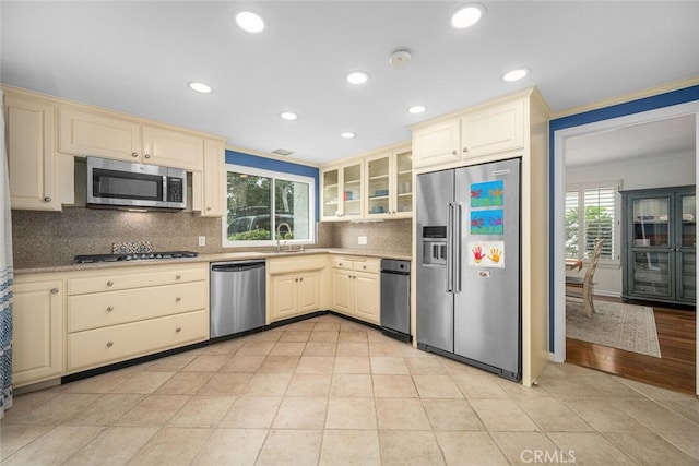 kitchen with cream cabinetry, stainless steel appliances, and a sink