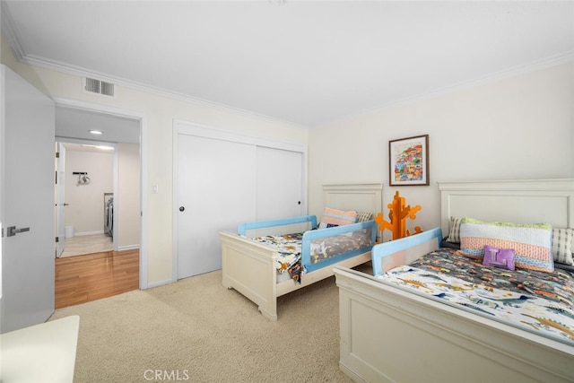 bedroom with light carpet, visible vents, a closet, and crown molding