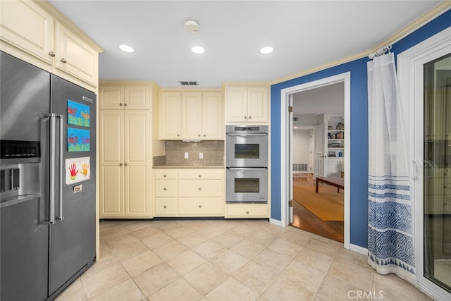 kitchen featuring tasteful backsplash, light tile patterned floors, cream cabinets, appliances with stainless steel finishes, and visible vents