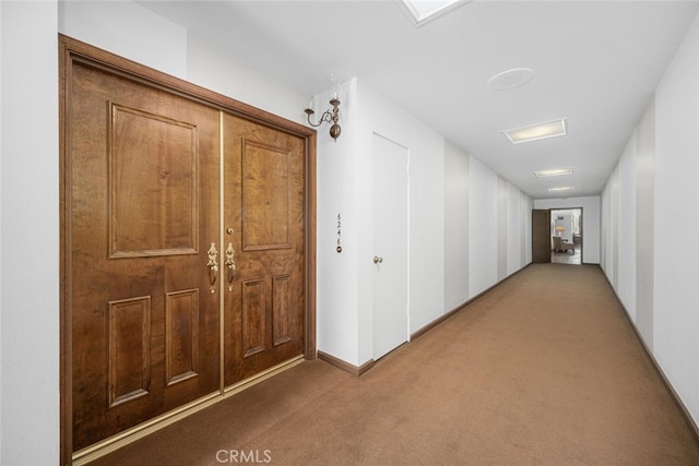 corridor with baseboards and carpet flooring