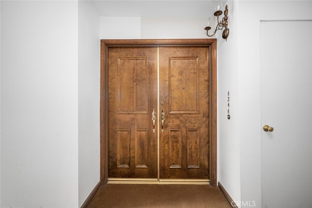 hall featuring carpet and baseboards