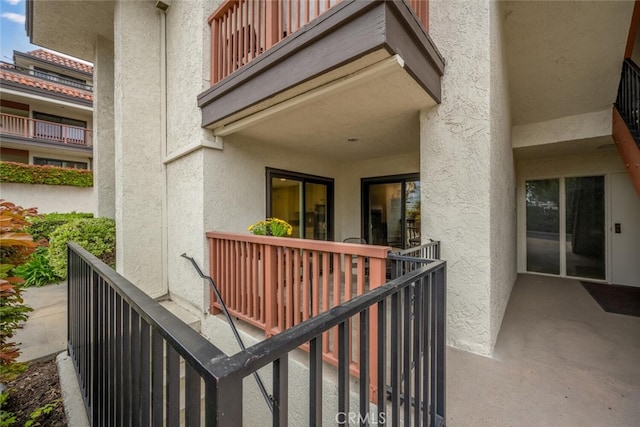 exterior space with a balcony and stucco siding