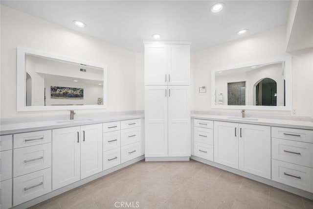 full bath with two vanities, a sink, and recessed lighting