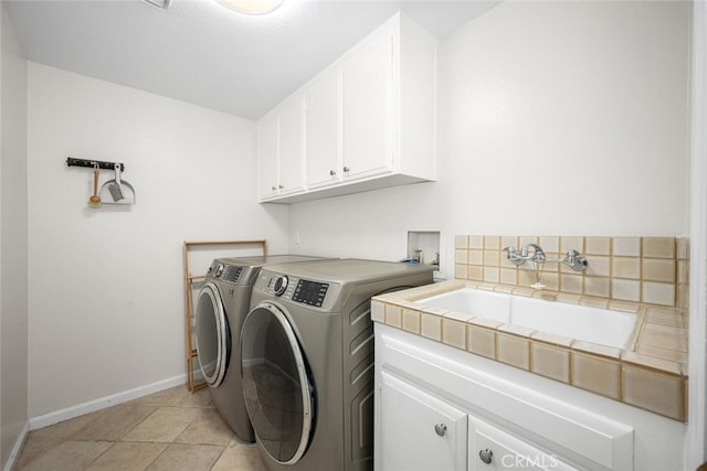 laundry room with washing machine and clothes dryer, baseboards, a sink, and cabinet space