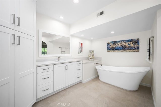 bathroom featuring a freestanding tub, vanity, tile patterned flooring, visible vents, and recessed lighting
