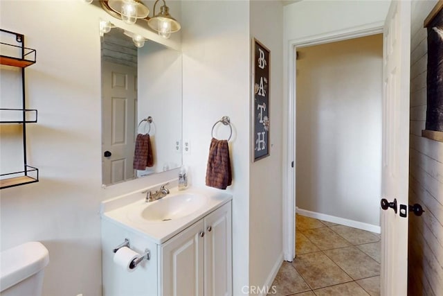 bathroom with baseboards, toilet, vanity, and tile patterned floors