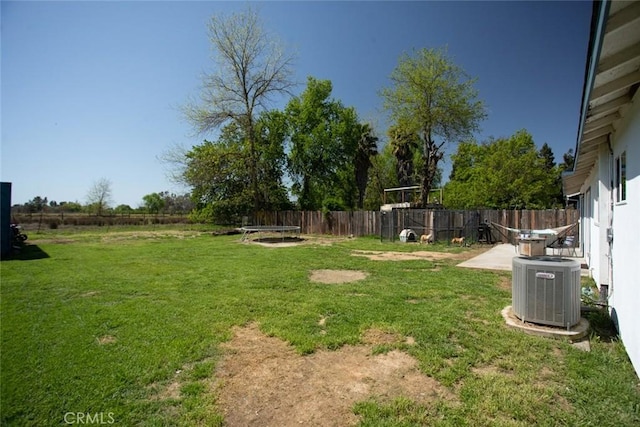 view of yard with a fenced backyard and central AC unit