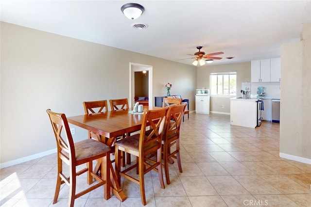 dining room with a ceiling fan, baseboards, and light tile patterned flooring