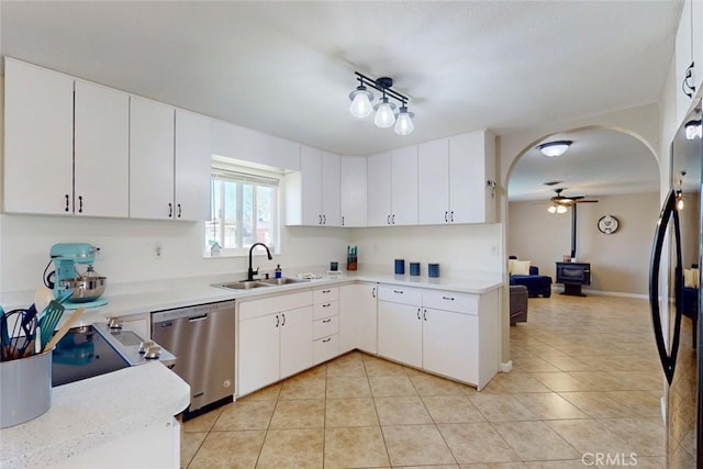 kitchen with a sink, light tile patterned floors, dishwasher, ceiling fan, and light countertops