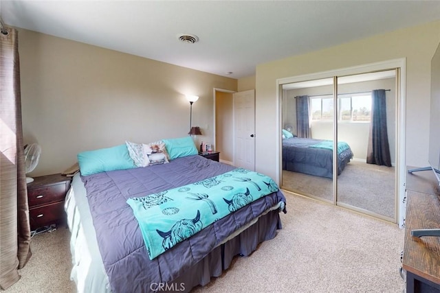 bedroom with a closet, light carpet, and visible vents